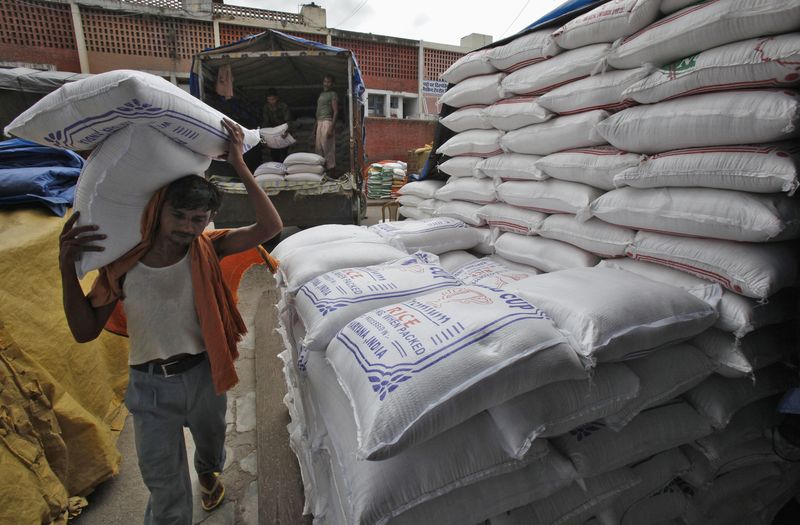 © Reuters.  A worker unloads bags filled with rice at a wholesale grain market in the northern Indian city of Chandigarh July 29, 2014. REUTERS/Ajay Verma/ FILE PHOTO